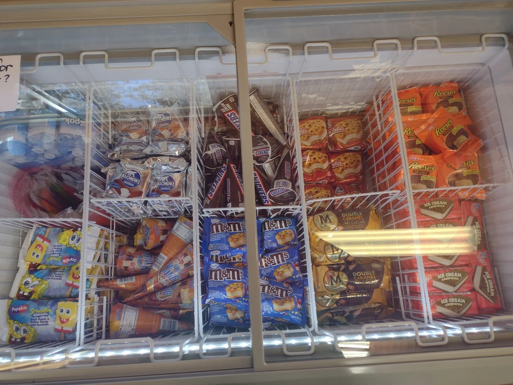 A selection of ice cream bars, sandwiches, cones, and frozen treats in the Outpost freezer