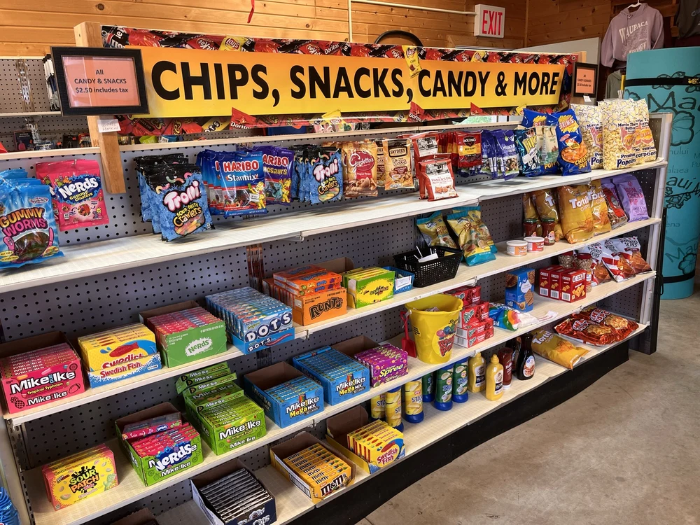 Shelves of chips, candy, popcorn, and other snacks inside the Outpost