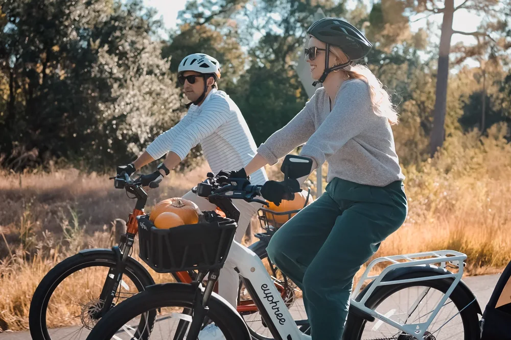 Two riders on e-bikes, from the existing Adventure Outfitters website