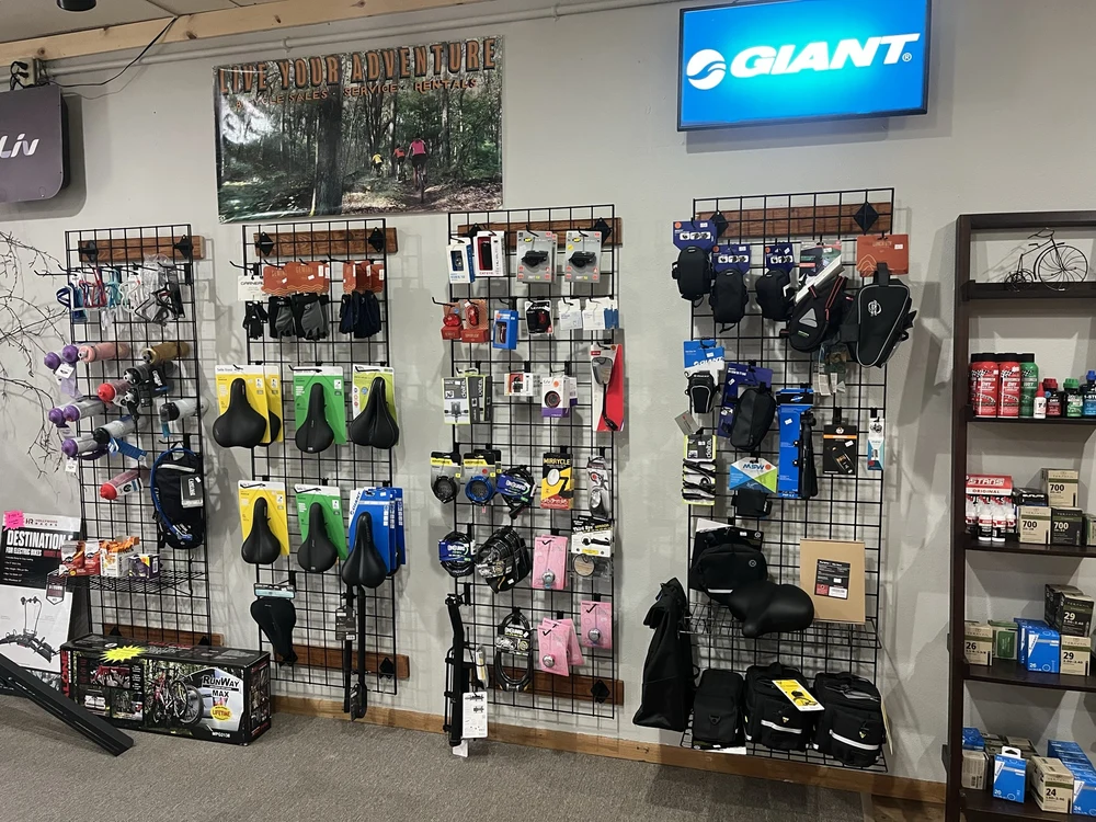 Bike helmets, bottles, saddles, lights, and other accessories displayed in the shop