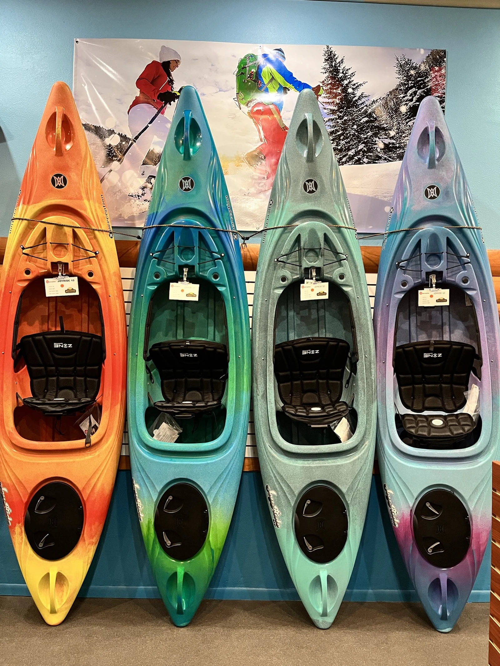 Colorful kayaks displayed inside Adventure Outfitters